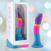 A brightly colored Avant D1 Hot 'n' Cool 6" Non-Porous Silicone Dildo with a curved design inside a clear plastic box. The toy features vibrant pink, blue, purple, and yellow colors. Packaging includes icons indicating body-safe and non-porous materials. A deep suction cup base ensures stability while the brand "Avant" is prominently printed on the box.